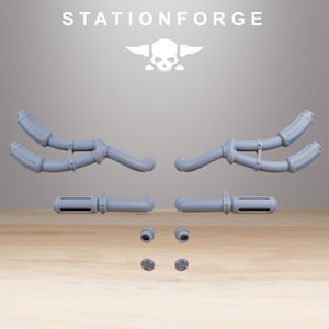 May include: A collection of light gray, 3D-printed components, including curved pipes, cylindrical pieces, and small circular parts. The text "STATIONFORGE" is displayed above a skull logo. The parts are arranged on a wooden surface.