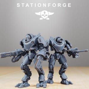 May include: Two gray, articulated robot figures with weapon attachments. The figures are standing side-by-side, with the text "STATIONFORGE" and a skull logo above them. The robots have detailed mechanical features.