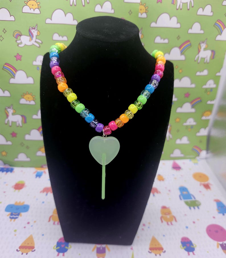 A neck model is wearing the green lollipop necklace