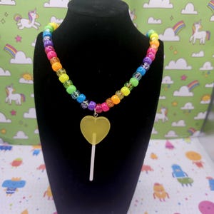 A neck model is wearing the yellow lollipop necklace