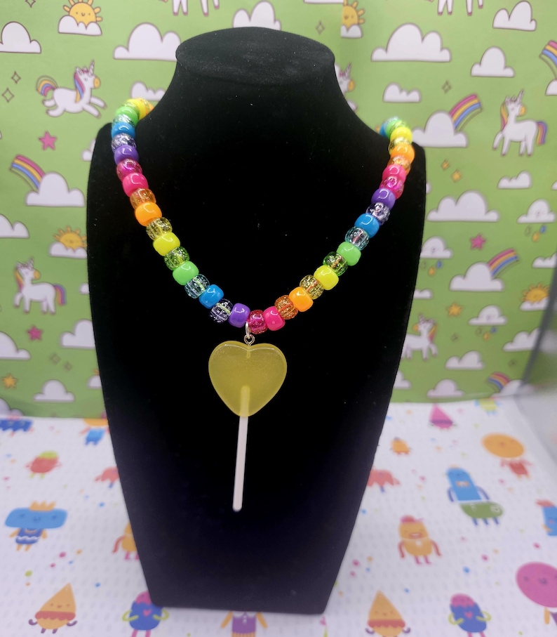 A neck model is wearing the yellow lollipop necklace