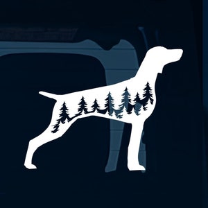 Peut inclure: Silhouette blanche d'un Braque allemand à poil court avec une scène de forêt à l'intérieur de la silhouette. Le chien se tient sur ses pattes arrière, les pattes avant tendues. La scène de forêt est composée de pins.