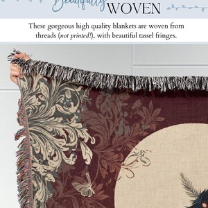 May include: A woven blanket with a dark red background and a cream-colored moon design. The blanket features a floral pattern in shades of gray and cream, with a black and white tassel fringe. The text "Beautifully WOVEN" is at the top.