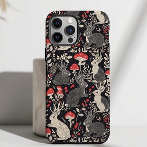 May include: Black phone case with a white and red pattern of stylized rabbits and mushrooms.