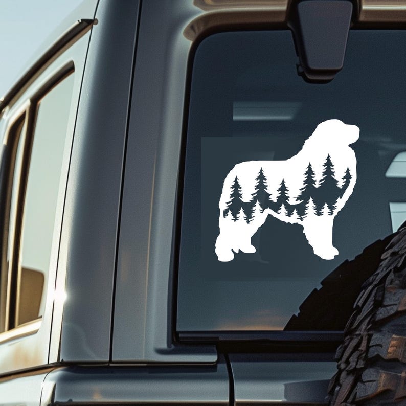 May include: White silhouette of a Bernese Mountain Dog with a forest scene inside the silhouette. The dog is standing on all four legs with its head facing to the right. The image is on a black car window.