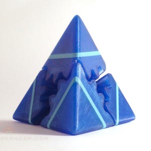 May include: A blue geometric puzzle with a pyramid shape. The puzzle is composed of interlocking triangular pieces, with light blue stripes. The puzzle is a brain teaser or a decorative object.