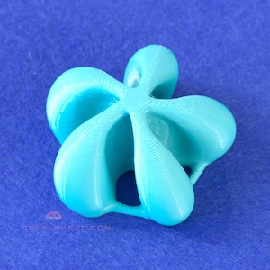 May include: A turquoise, abstract 3D-printed sculpture with a complex, flowing design. The object has a symmetrical, multi-lobed shape, with smooth, curved surfaces and visible layer lines from the printing process. The sculpture is set against a blue background.