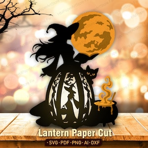 May include: A black paper cut design featuring a witch in a pointed hat holding a book, positioned above a lantern with cut-out witch silhouettes. A large orange moon, a black cat, and a bubbling cauldron with yellow steam are included in the scene.