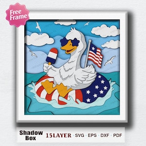 May include: A layered paper art piece featuring a white goose wearing sunglasses and floating on a patriotic-themed inner tube. The goose holds an ice pop and an American flag. The artwork is set against a blue sky with clouds and seagulls. The text "Shadow Box" and "15 LAYER SVG EPS DXF PDF" are visible.