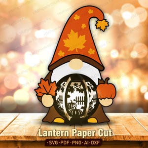 Può includere: Un'illustrazione di uno gnomo che indossa un cappello alto arancione con motivi a foglia d'acero, una barba bianca e un cappotto marrone. Lo gnomo tiene in mano una foglia d'acero arancione e una zucca, incorniciando una lanterna centrale.