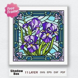 May include: A stained glass style digital art design featuring purple iris flowers with green leaves in a blue and white frame. The design is labeled "Shadow Box 11 LAYER SVG EPS DXF PDF".