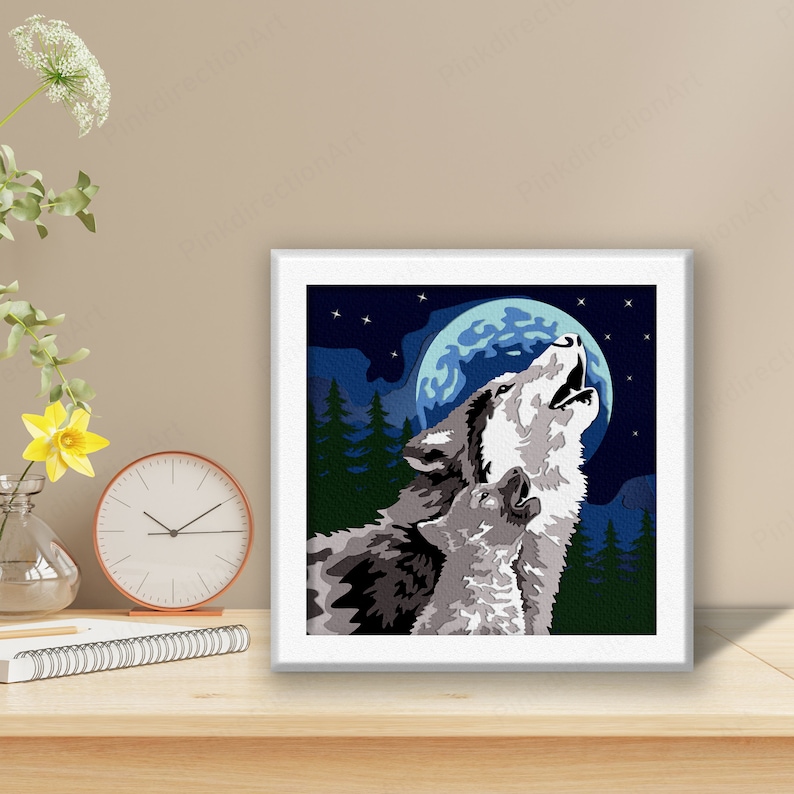 May include: A framed print of a wolf howling at the moon. The wolf is gray and white, and the moon is blue and white. The background is a dark blue night sky with stars.
