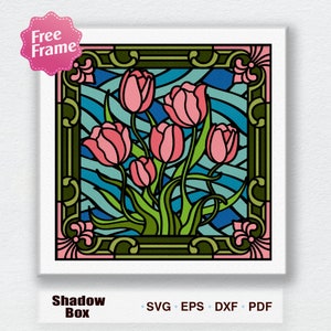 Op de afbeelding: Een afbeelding in de stijl van een glas-in-loodraam met roze tulpen in een groen frame. De achtergrond is een blauw en groen golvend patroon. De afbeelding is gelabeld "Shadow Box" en bevat de tekst "SVG, EPS, DXF, PDF".