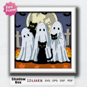 May include: A layered paper shadow box art piece in a white frame featuring three white ghosts and three black cats with green eyes. The scene includes a large full moon, a dark blue night sky with bats, a graveyard, and orange pumpkins.