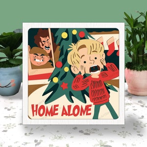 May include: A white framed illustration of a boy with a red sweater and a Christmas tree in the background. The boy is looking scared and has his hands over his face. The text "Home Alone" is written in red and white letters at the bottom of the illustration.