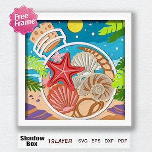 May include: A white frame with a colorful paper cut design of a glass bottle filled with seashells, a starfish, and a piece of coral. The bottle is on a sandy beach with palm trees and a moon in the background. The text "Shadow Box 19 LAYER" is below the frame.