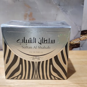 May include: A silver and black box with a zebra print design. The box has the text "Sultan Al Shabab" and "Eau de Parfum" printed on it.
