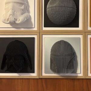 Puede incluir: Seis piezas de arte de pared enmarcadas con esculturas 3D de personajes de Star Wars. Las esculturas est&aacute;n hechas de papel y est&aacute;n pintadas en varios colores, incluyendo blanco, negro, dorado y naranja. Los marcos est&aacute;n hechos de madera y tienen un acabado marr&oacute;n claro.