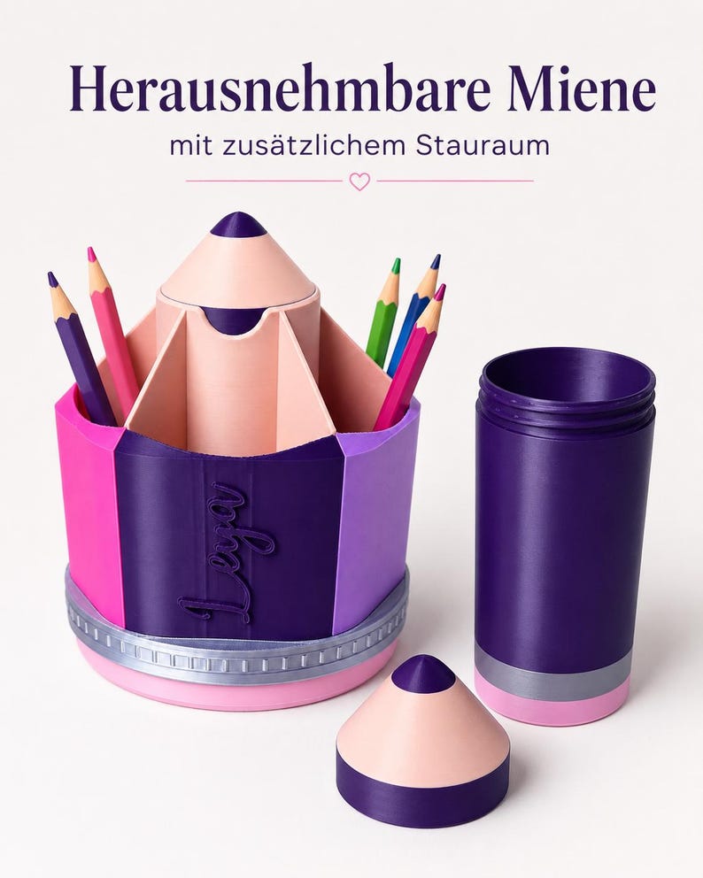 May include: A pencil-shaped desk organizer in shades of purple, pink, and light peach, featuring a removable top section, a central compartment for pens, and the name "Leya" embossed on the side. The text "Herausnehmbare Miene mit zus&auml;tzlichem Stauraum" is visible.