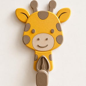 May include: A wall-mounted hook shaped like a cartoon giraffe head. The giraffe is yellow with brown spots, brown ossicones, and a light beige muzzle. Below the head, a brown hook extends outward, featuring a textured surface and a rounded end.