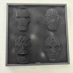 May include: A black framed wall art piece with three faces sculpted in a 3D style. The faces are made of thin, vertical lines that create a textured effect.