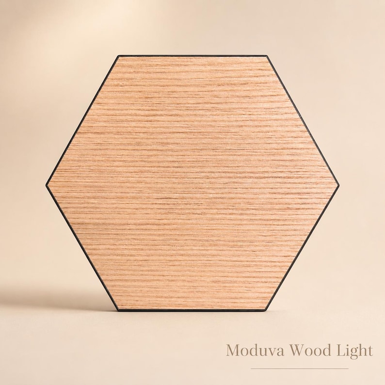 May include: Hexagonal wooden light fixture with a black border. The light has a natural wood grain pattern and the text "Moduva Wood Light" is at the bottom.