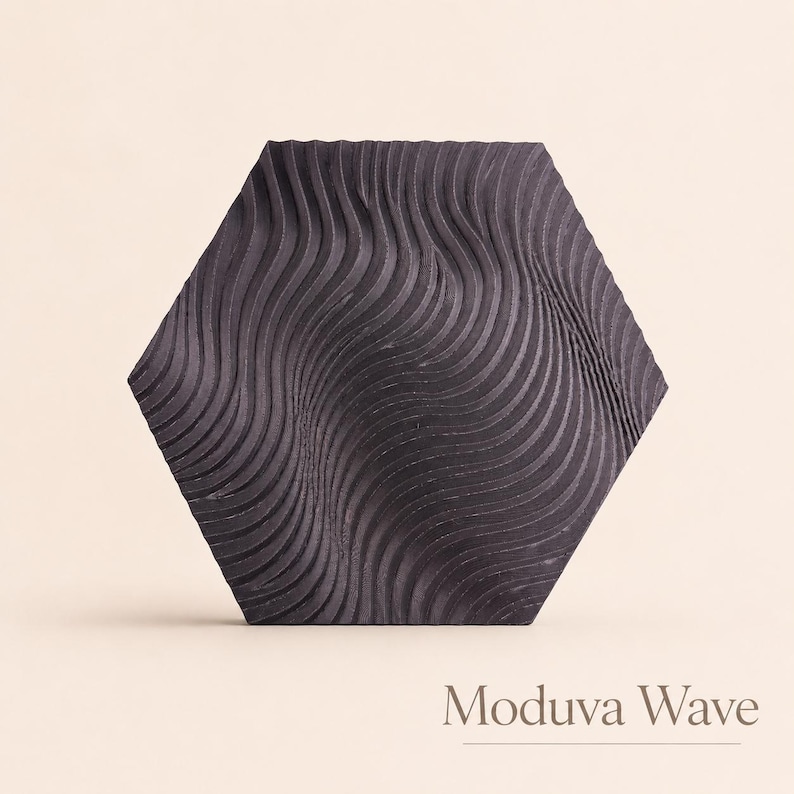 May include: A dark gray, hexagonal tile with a wave-like pattern. The tile's surface features a series of curved, parallel lines that create a textured effect. The text "Moduva Wave" is displayed at the bottom of the image.