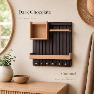 May include: A wall-mounted organizer featuring a dark brown slatted back panel with six small pegs at the bottom. It includes a square storage box, a narrow horizontal shelf, and a wider bottom shelf, all in a light tan color. Text reads Dark Chocolate.