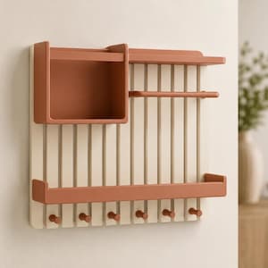 May include: A wall-mounted organizer featuring a cream-colored slatted back panel with terracotta-colored accents. It includes a square storage box, a horizontal bar, a long shelf, and six small pegs at the bottom for hanging various items.