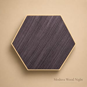 May include: A hexagonal wooden panel with a dark gray wood grain pattern. The panel is framed with a thin, light-colored border. The text "Moduva Wood Night" is at the bottom.
