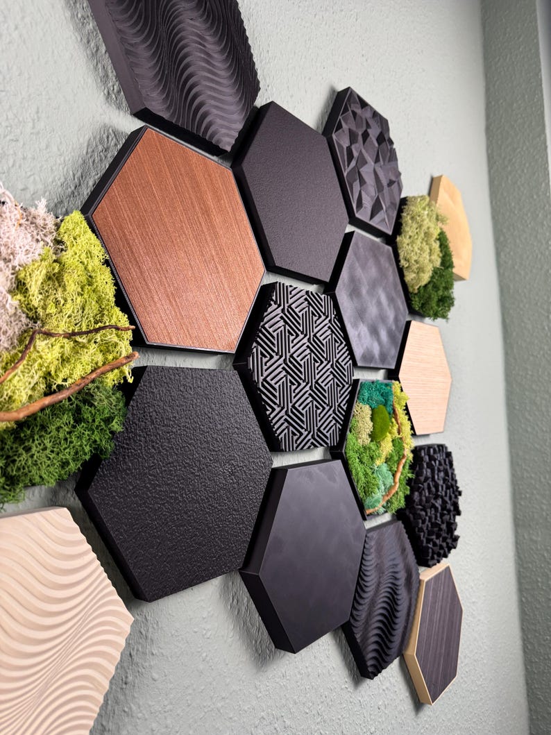 May include: A collection of hexagonal wall panels in various textures and colors, including wood grain, black, and patterned designs. Some panels feature moss and natural elements, creating a modern, textured wall art installation.