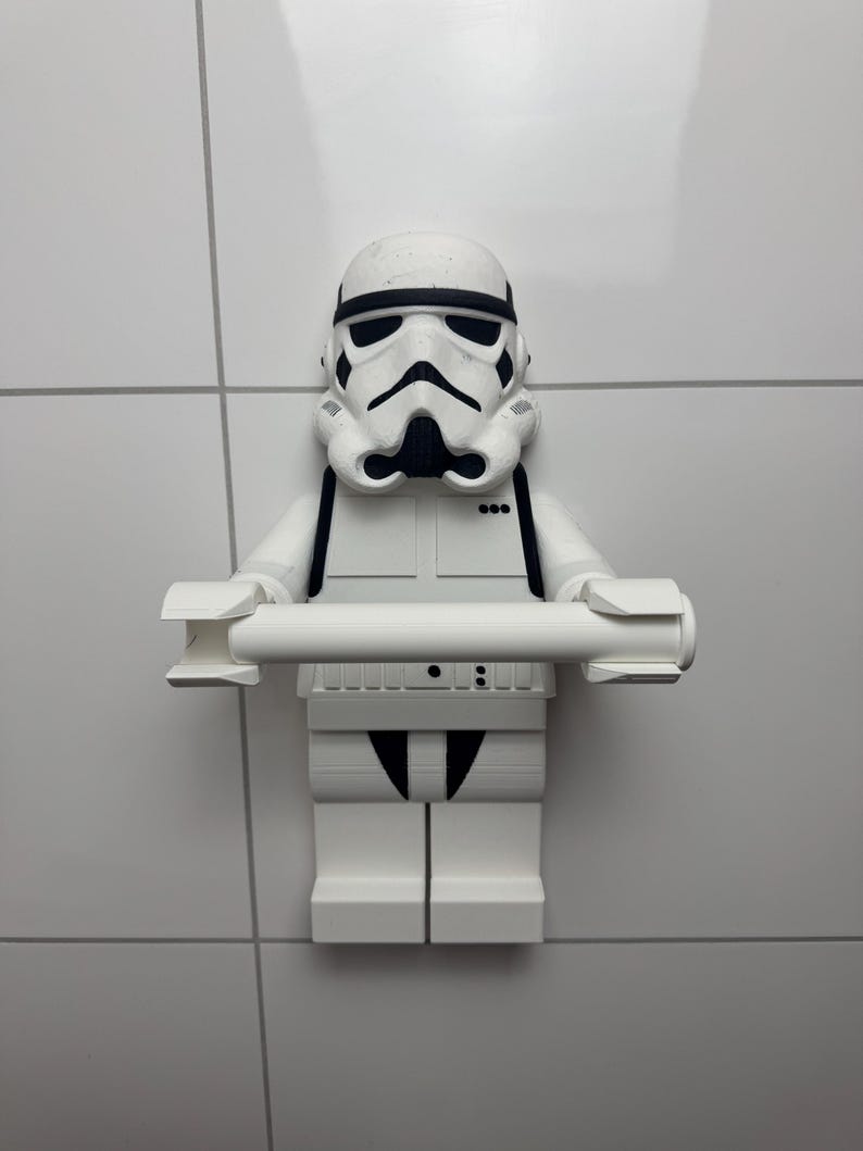 May include: White plastic Star Wars Stormtrooper figurine toilet roll holder. The figurine is holding a roll of toilet paper in its hands.