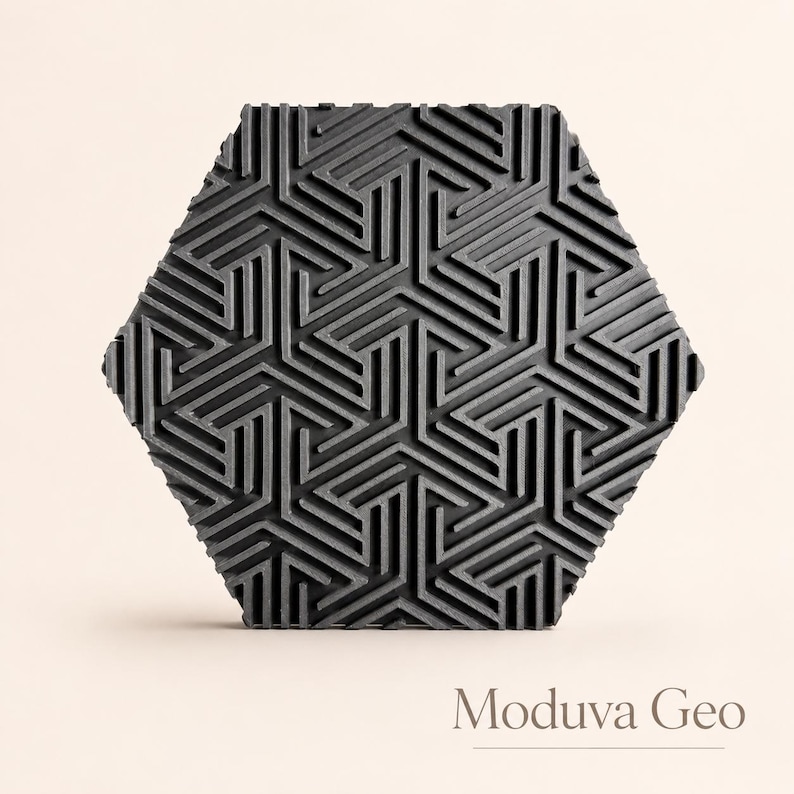 May include: A dark gray, hexagonal tile with a geometric pattern of intersecting lines. The tile's surface has a textured appearance, and the design is repeated across the entire surface. The text "Moduva Geo" is at the bottom.