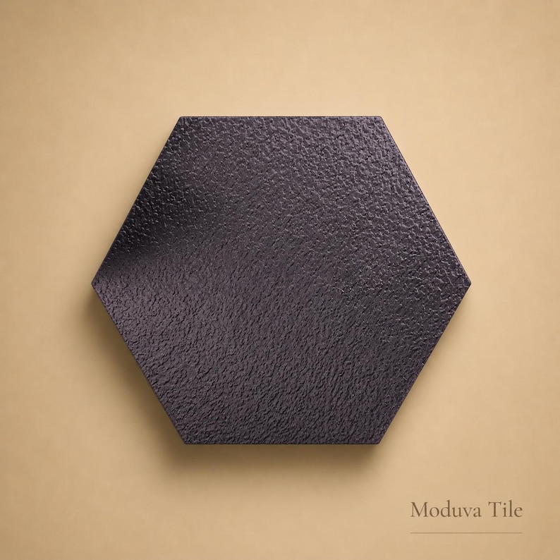 May include: A dark gray, textured, hexagonal tile. The tile has a rough surface and is set against a tan background. The text "Moduva Tile" is at the bottom right.