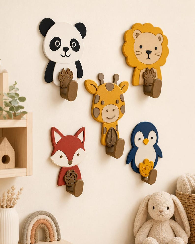 May include: A set of five wall-mounted animal hooks featuring a panda, lion, giraffe, fox, and penguin. Each hook is shaped like an animal face with a corresponding paw or foot print design on the brown hook base, providing functional storage.