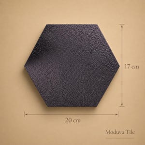 May include: A black, textured, hexagonal tile, 20 cm wide and 17 cm high. The tile has a rough surface and is displayed against a neutral background. The text "Moduva Tile" is visible.