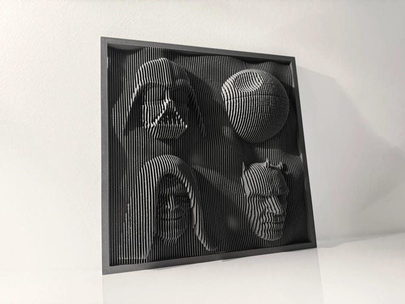 May include: A black framed wall art piece with a 3D design of four characters from Star Wars. The characters are Darth Vader, Princess Leia, Chewbacca, and a Death Star.