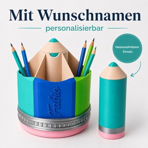 May include: A multi-colored pencil-shaped desk organizer with a removable center insert. The organizer features teal, blue, and green segments, a silver-toned band, and a pink base. The name Fabio is embossed on the blue side panel.