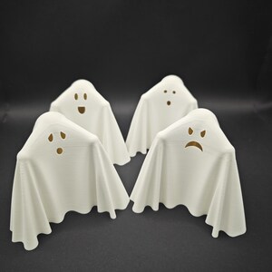 Puede incluir: Cuatro figuritas de fantasmas blancas con diferentes expresiones faciales. Los fantasmas est&aacute;n hechos de un material blanco liso y tienen un dise&ntilde;o simple y cl&aacute;sico.