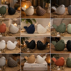 May include: A collection of decorative bird figurines in various colors, including green, black, white, and terracotta. The birds have a textured, ribbed design and are displayed on woven mats and books. These home decor items add a touch of nature to any space.