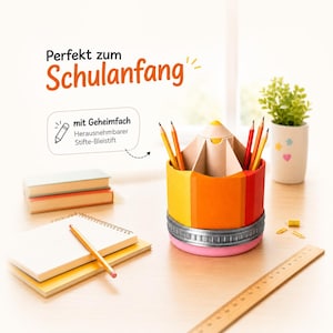May include: A pencil-shaped desk organizer with yellow, orange, and red segments, a silver metal band, and a pink base. It holds several colored pencils. Text reads: Perfekt zum Schulanfang, mit Geheimfach, Herausnehmbarer Stifte-Bleistift.