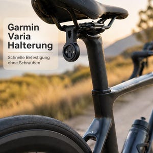 Może przedstawiać: Czarne siodełko rowerowe z dołączonym urządzeniem Garmin Varia Halterung. Tekst na zdjęciu brzmi "Garmin Varia Halterung" i "Schnelle Befestigung ohne Schrauben". Rower ma czarną ramę, koło i bidon.