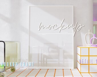 Op de afbeelding: Witte frame mockup op een witte muur met een plankeneenheid op de achtergrond. De plankeneenheid heeft een paarse achtergrond en bevat een radio, een klein beeldje en een glazen bol. De tekst "HIGH RESOLUTION" en "DETAIL VIEW" is zichtbaar op de afbeelding.