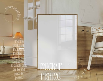 May include: A white picture frame mockup in a room with wooden floors, a white chair, and a lamp. The text "MOCKUP FRAME" is written on the floor in front of the frame.