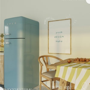 Può includere: Un frigorifero azzurro chiaro con un tavolo di legno e una sedia di fronte. Una cornice di legno con il testo "your design here" è appesa al muro.