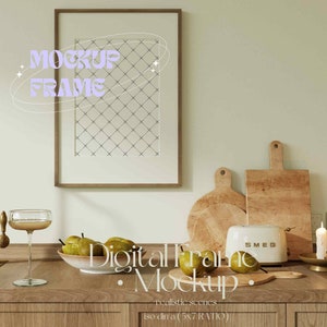Pu&ograve; includere: Un mockup di cornice digitale in un'ambientazione da cucina. La cornice &egrave; appesa a una parete verde chiaro sopra un bancone in legno. Sul bancone ci sono taglieri di legno, un tostapane e una ciotola di pere.