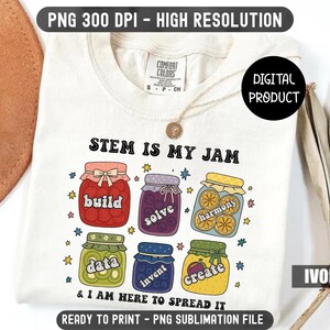 Pode incluir: Camiseta cor marfim com a frase "STEM IS MY JAM" e ilustrações coloridas de potes de geleia. Cada pote contém uma palavra diferente: build, solve, harmony, data, invent e create. A camiseta é um produto digital.