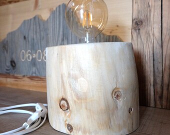Edison bulb lamp made of wood recovered from the Belluno Dolomites after the 2018 Vaia disaster.
