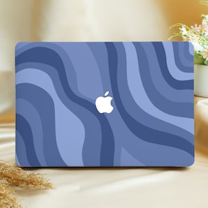 Könnte beinhalten: Eine blaue und violette Laptop-Haut mit einem wellenförmigen Muster. Die Haut hat ein weißes Apple-Logo in der Mitte.