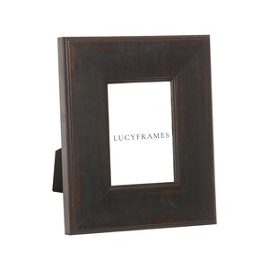 May include: A black wooden picture frame with a simple design. The frame has a stand on the back and the text "LUCYFRAMES" is visible inside the frame.